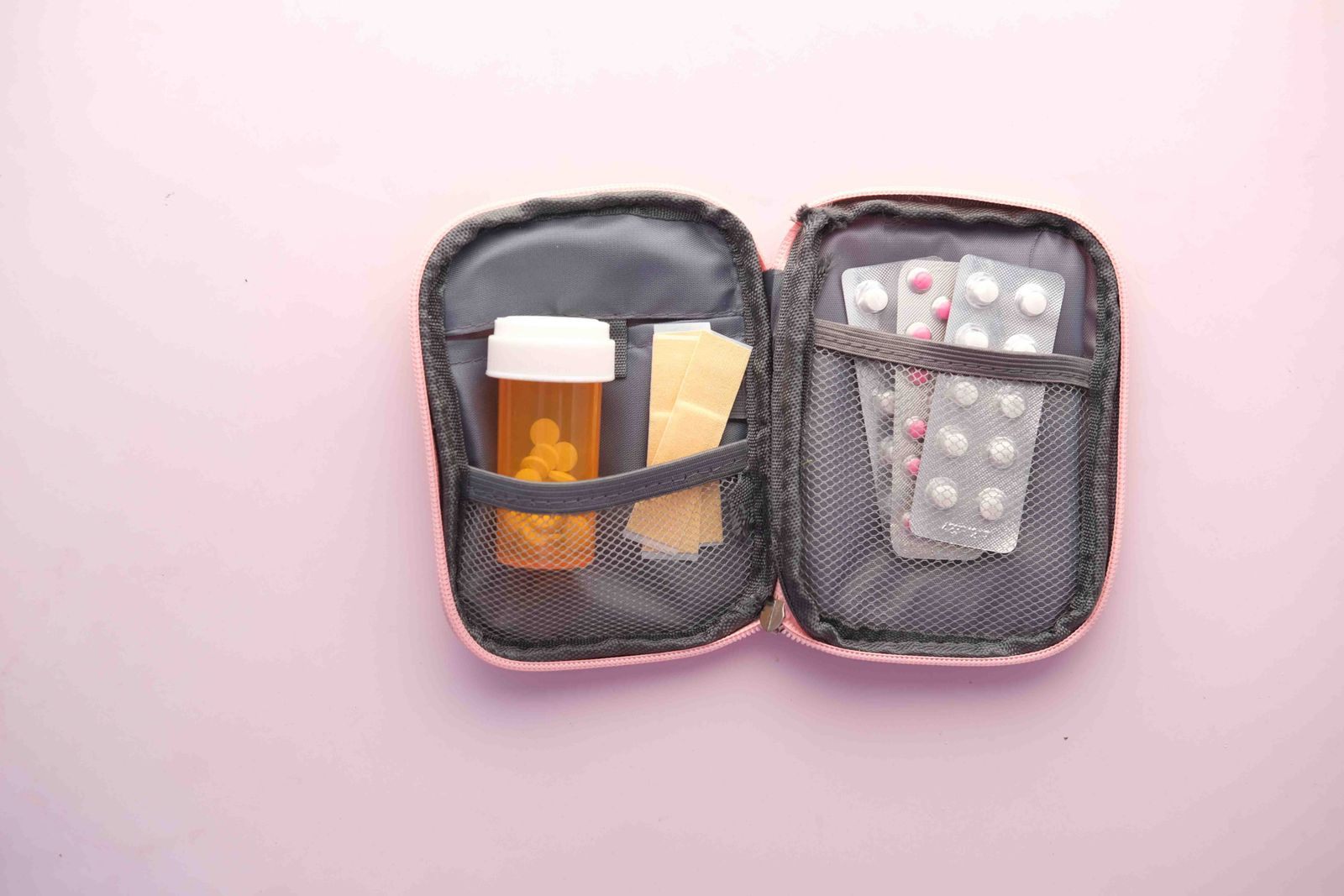 Open first aid kit with pill bottle, blister packs and plasters, the medicines seniors pack for a cruise